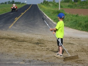 Peter Klessig helps clean the part of the road where the herd crossed.
