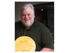 Jerry Heimerl holding a wheel of Saxon Creamery cheese
